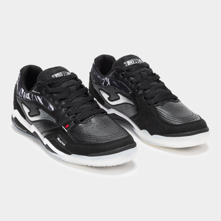 Pair of JOMA FS Reactive 2501 turf futsal trainers in black, angled view highlighting VTS mesh and toe protection.