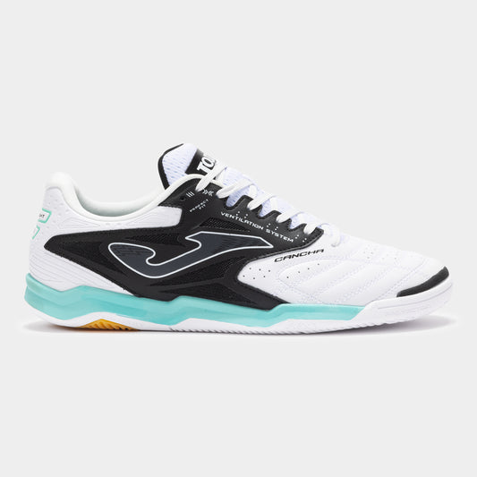 JOMA Cancha 2502 futsal trainer in white and black, showing lateral branding and low-cut design.