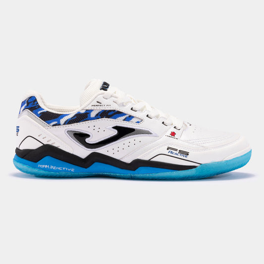 JOMA FS Reactive 2432 turf football shoe in white and royal blue, side view showing leather upper, VTS vents, and toe protection.
